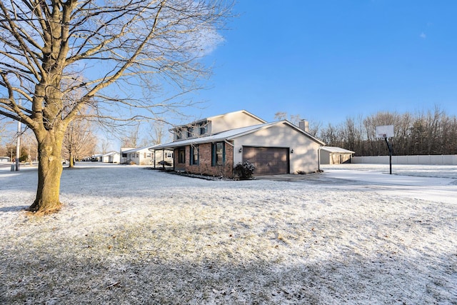 view of snow covered exterior with a carport and a garage