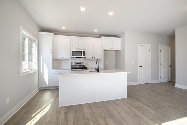 304 Ash St, South Haven, MI 49090 - kitchen featuring baseboards, an island with sink, appliances with stainless steel finishes, and a sink