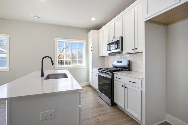 304 Ash St, South Haven, MI 49090 - kitchen with tasteful backsplash, recessed lighting, appliances with stainless steel finishes, light wood finished floors, and a sink