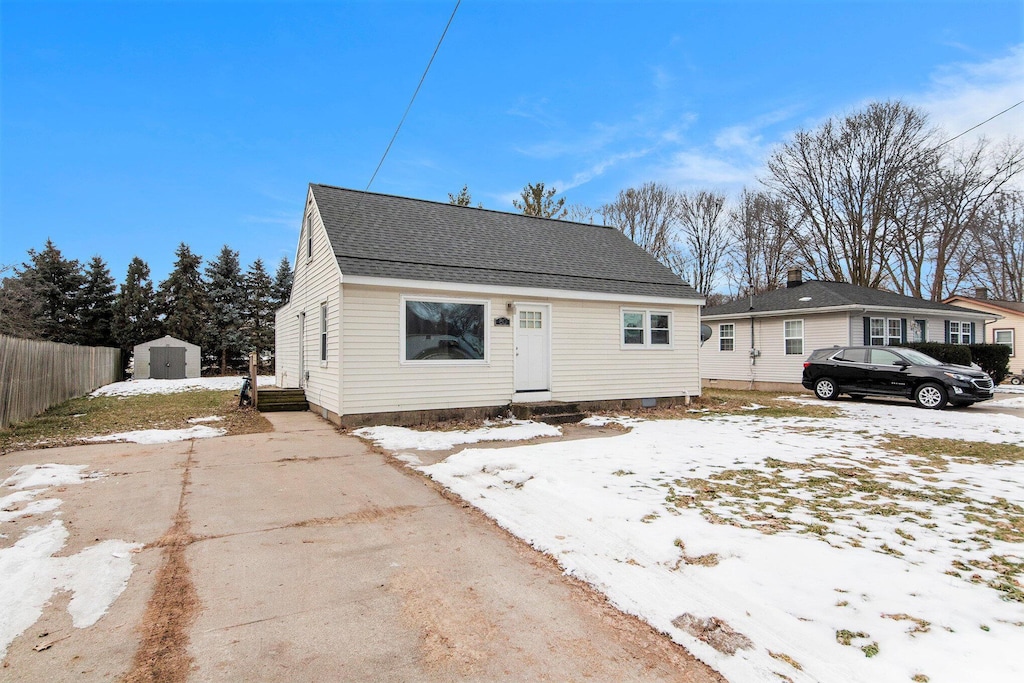 bungalow-style home with a storage shed