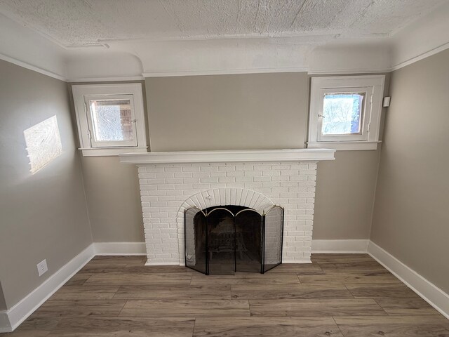 interior details featuring baseboards, a brick fireplace, and wood finished floors