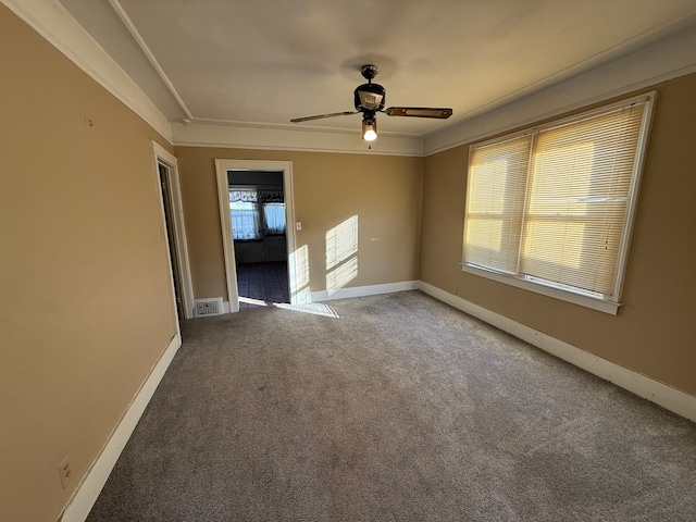 carpeted spare room featuring ornamental molding and ceiling fan