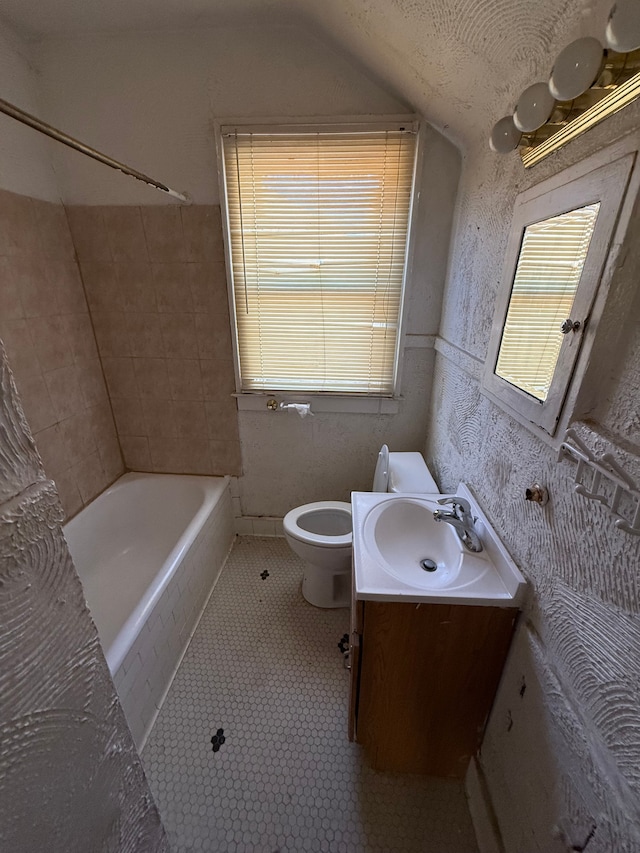 full bathroom featuring vanity, vaulted ceiling, a wealth of natural light, and toilet