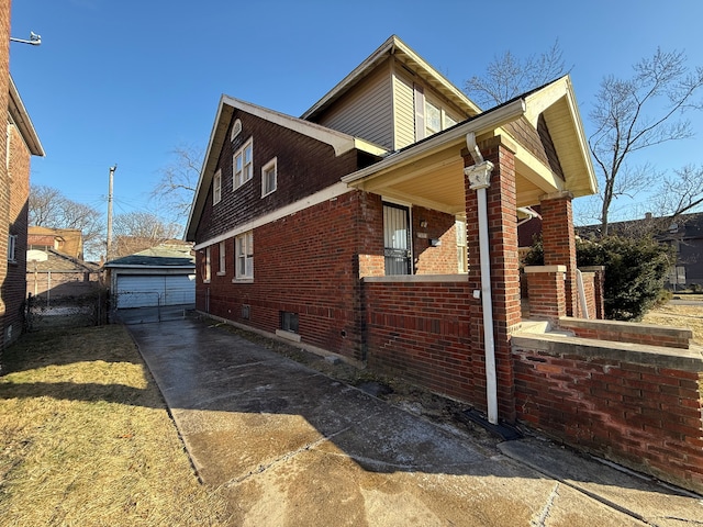 view of home's exterior with a garage, a porch, and an outbuilding