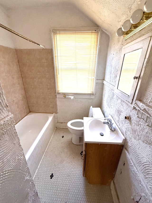 bathroom featuring vanity, vaulted ceiling, toilet, and tile patterned flooring