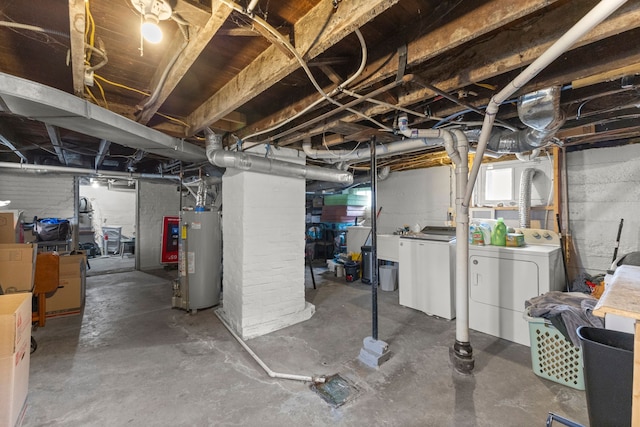 basement with water heater, washing machine and dryer, and sink