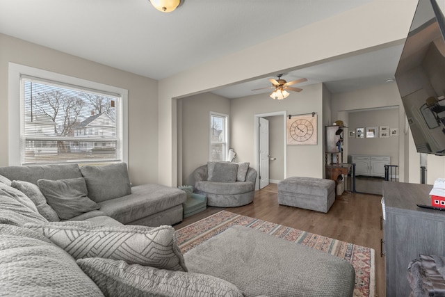 living room with dark wood-type flooring and ceiling fan