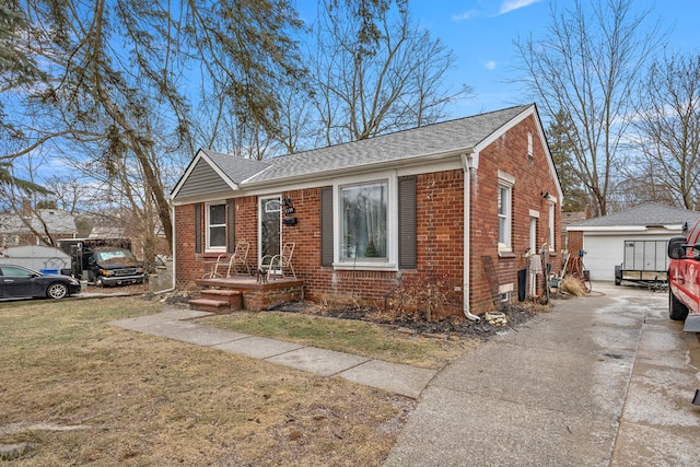 bungalow-style house featuring a garage, an outbuilding, and a front yard