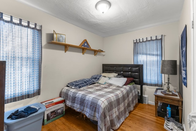 bedroom featuring wood-type flooring and a textured ceiling