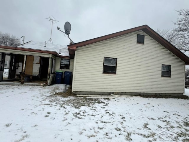 view of snow covered rear of property