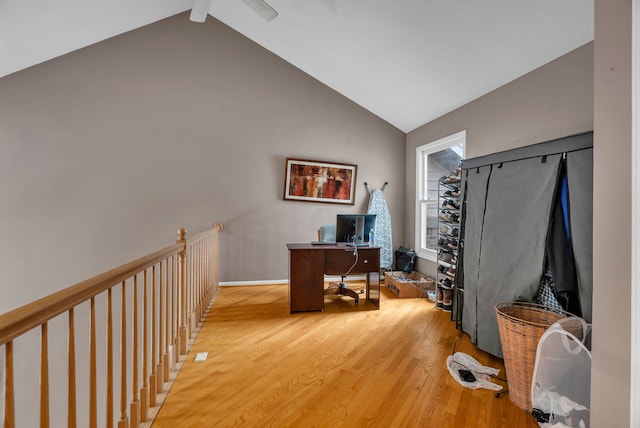 office with high vaulted ceiling and light hardwood / wood-style floors