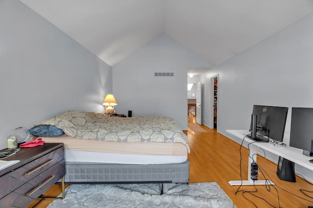 bedroom with wood-type flooring and vaulted ceiling