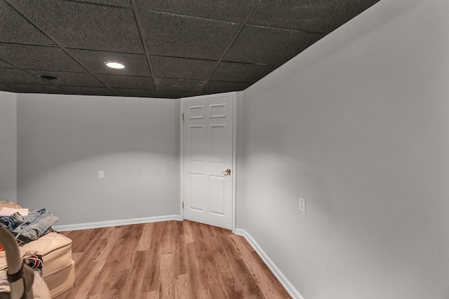 basement with a drop ceiling and wood-type flooring