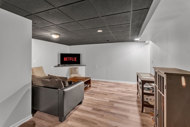 living room featuring wood-type flooring and a drop ceiling