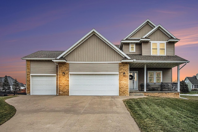 craftsman inspired home featuring a garage, a yard, and covered porch