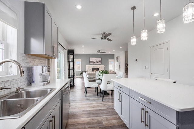 kitchen with sink, backsplash, gray cabinets, and dark hardwood / wood-style floors