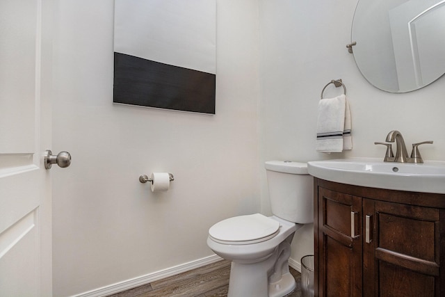 bathroom with wood-type flooring, toilet, and vanity