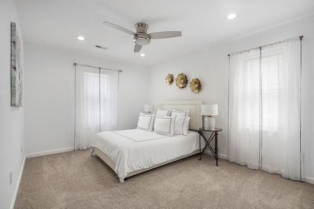 carpeted bedroom with multiple windows and ceiling fan