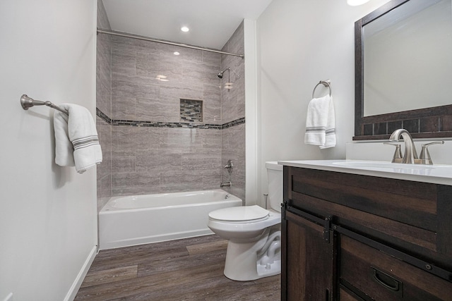 full bathroom featuring vanity, hardwood / wood-style floors, toilet, and tiled shower / bath