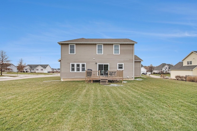 rear view of property with a yard and a deck