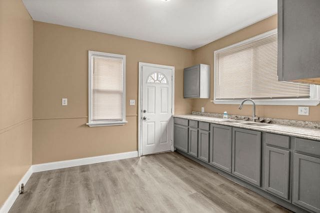 kitchen featuring gray cabinets, sink, and light wood-type flooring