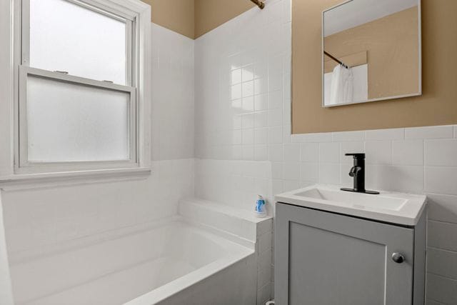 bathroom with tile walls and vanity