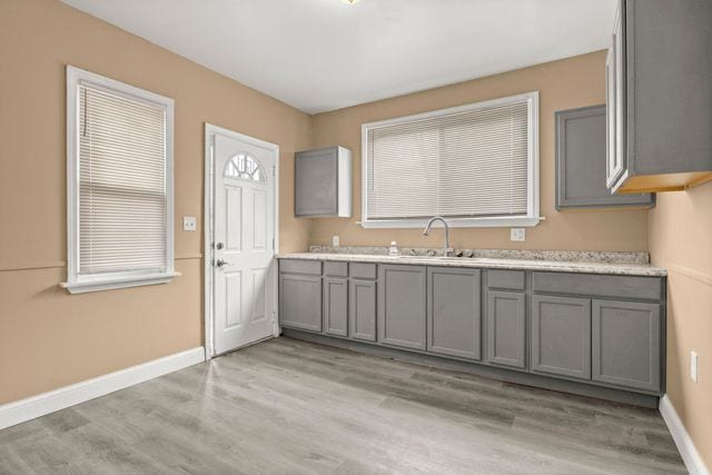 kitchen featuring gray cabinets, sink, and light hardwood / wood-style floors