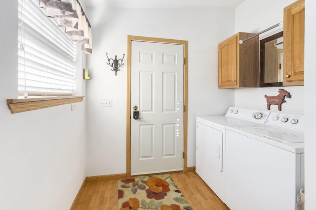 washroom featuring independent washer and dryer, light hardwood / wood-style floors, and cabinets