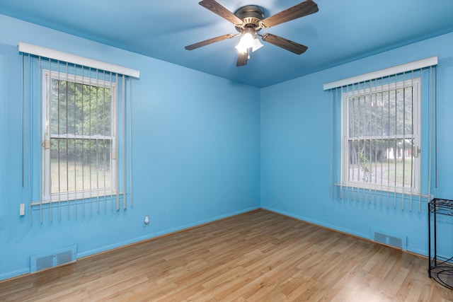 empty room with ceiling fan and light hardwood / wood-style flooring