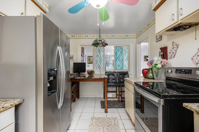 kitchen featuring appliances with stainless steel finishes, white cabinetry, light tile patterned floors, light stone counters, and ceiling fan