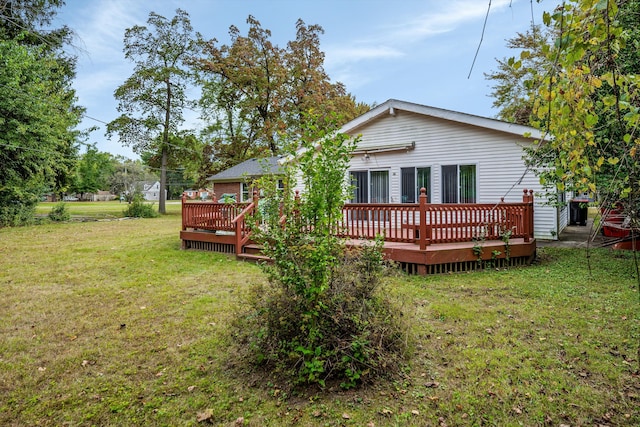 rear view of property featuring a deck and a lawn