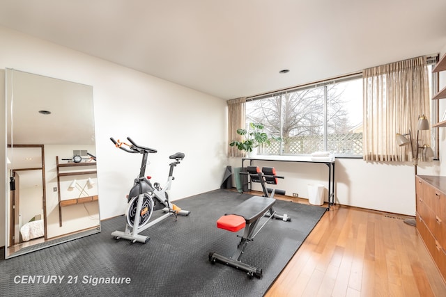 exercise room with light wood-type flooring