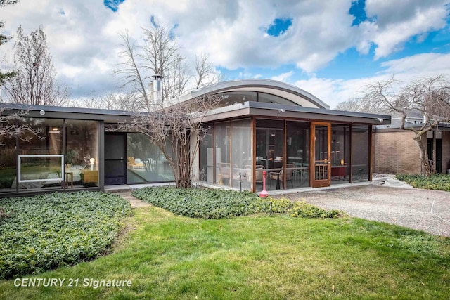 back of house with a sunroom and a yard