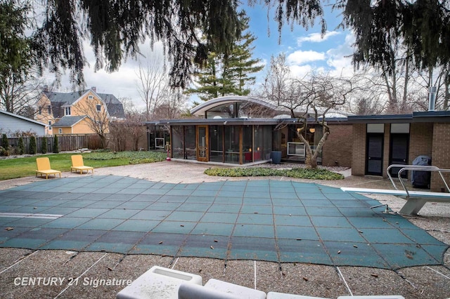 view of pool featuring a patio, a sunroom, a diving board, and a lawn