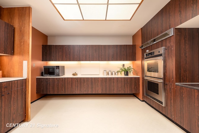 kitchen featuring dark brown cabinets and double oven