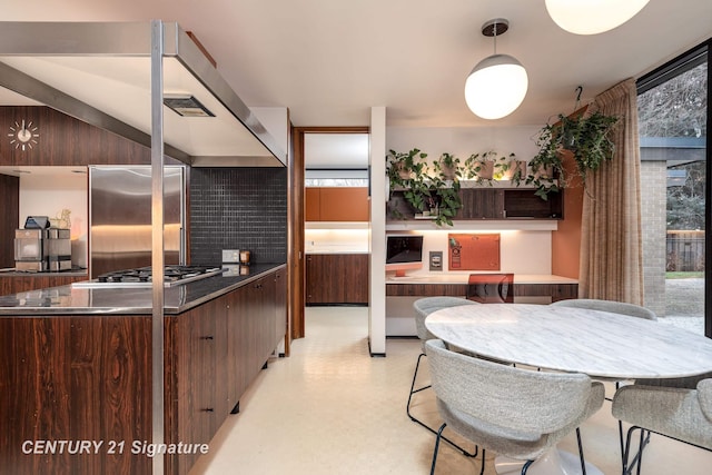 kitchen featuring tasteful backsplash, stainless steel built in fridge, and dark brown cabinetry