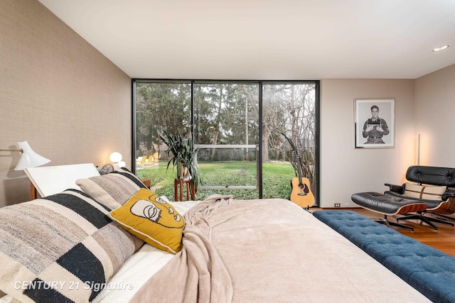 bedroom featuring hardwood / wood-style floors and a wall of windows