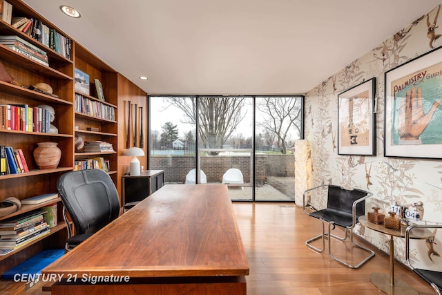 office area with light hardwood / wood-style flooring and expansive windows