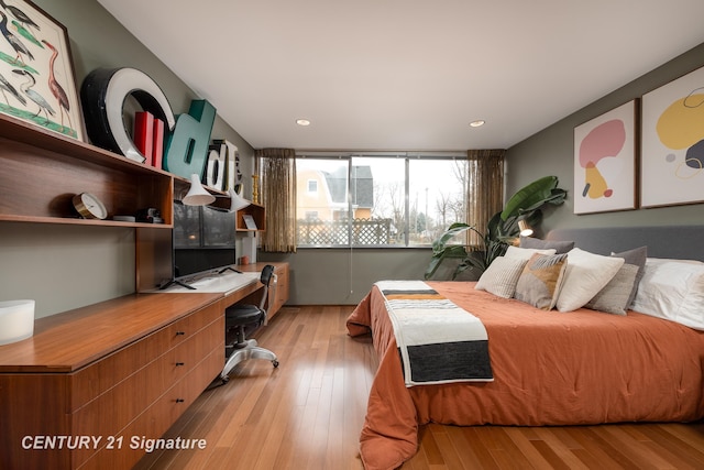 bedroom featuring built in desk and light wood-type flooring