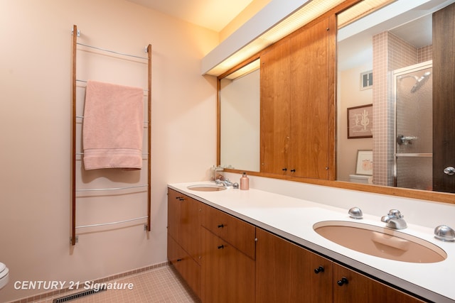 bathroom with tile patterned floors, vanity, toilet, and an enclosed shower