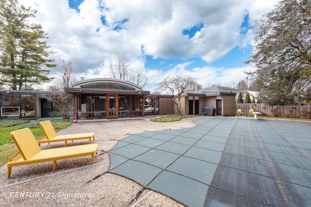 view of swimming pool featuring area for grilling, a sunroom, and a patio