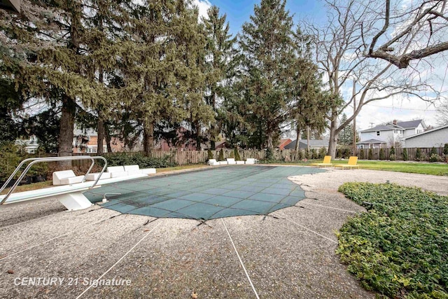 view of pool featuring a diving board and a patio