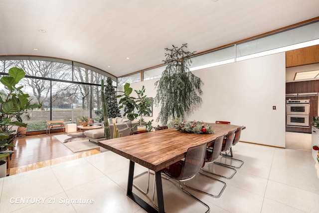 tiled dining room with lofted ceiling