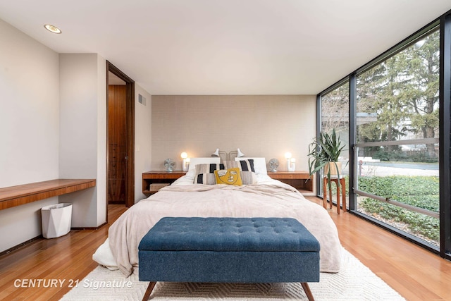 bedroom featuring hardwood / wood-style flooring and floor to ceiling windows