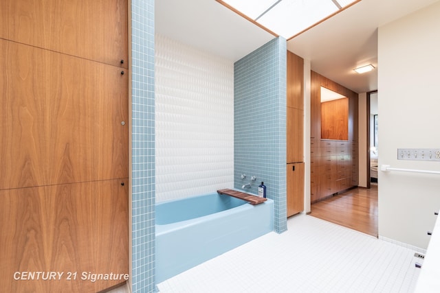 bathroom with tile patterned flooring and a tub