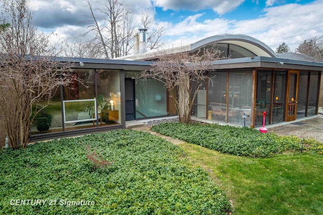 back of property with a sunroom