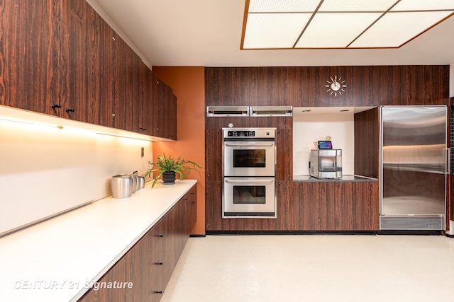 kitchen featuring appliances with stainless steel finishes and dark brown cabinets