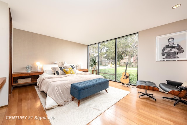 bedroom with light hardwood / wood-style flooring and floor to ceiling windows