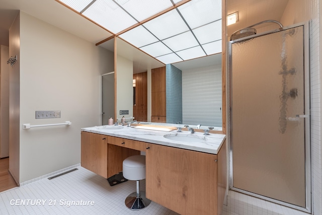 bathroom with walk in shower, vanity, and tile patterned flooring