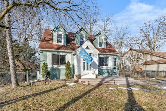 new england style home with a wooden deck and a front yard